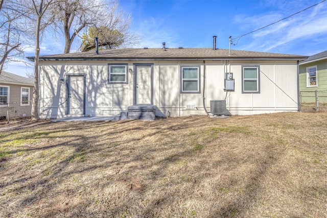 rear view of house with a yard and central AC unit