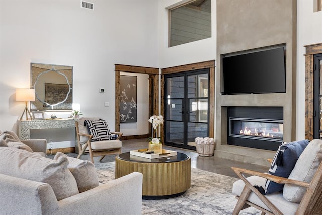 living room featuring a towering ceiling and hardwood / wood-style floors