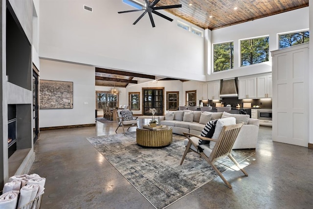 living room with a high ceiling, an inviting chandelier, wood ceiling, and beam ceiling