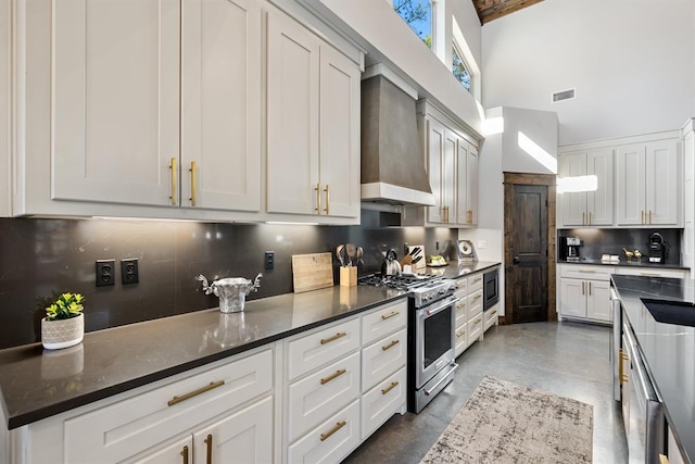 kitchen featuring stainless steel appliances, white cabinetry, tasteful backsplash, and wall chimney range hood