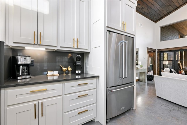 kitchen featuring vaulted ceiling, high end refrigerator, backsplash, white cabinets, and wood ceiling