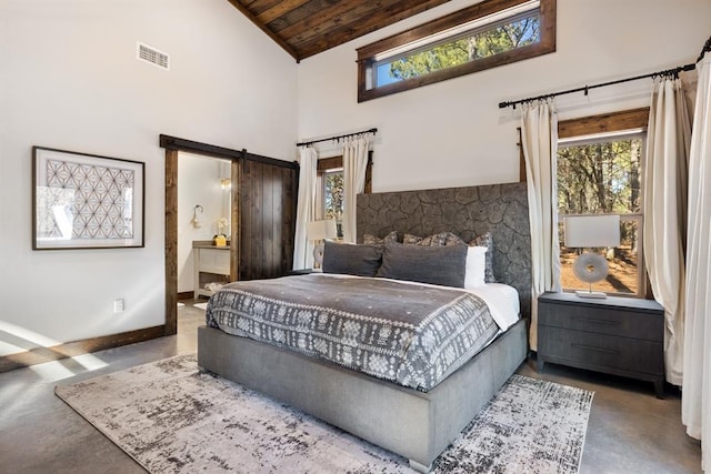 bedroom with concrete flooring, high vaulted ceiling, wood ceiling, a barn door, and ensuite bath