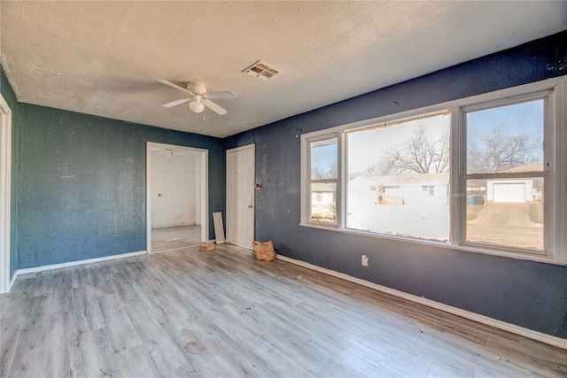 unfurnished bedroom with a textured ceiling, ceiling fan, and light hardwood / wood-style flooring