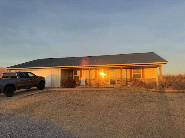 728 S Carol St, Carnegie, OK 73015 - view of front of house with a garage, driveway, covered porch, and metal roof