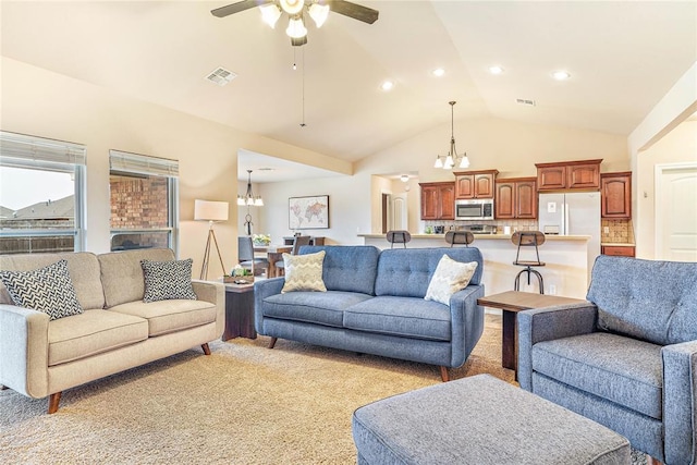 living room featuring ceiling fan with notable chandelier, high vaulted ceiling, and light colored carpet