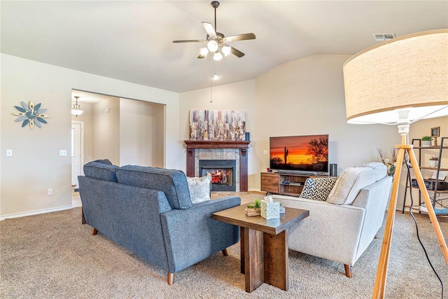 carpeted living room featuring a tile fireplace, vaulted ceiling, decorative columns, and ceiling fan