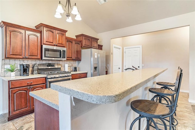 kitchen with pendant lighting, a breakfast bar area, stainless steel appliances, and a center island with sink