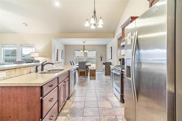 kitchen featuring stainless steel appliances, sink, an inviting chandelier, and decorative light fixtures