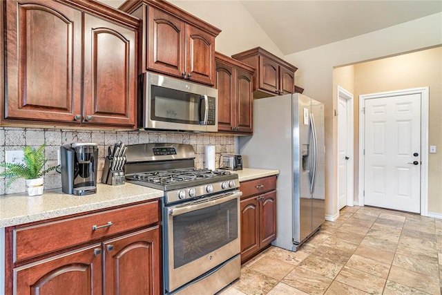 kitchen featuring stainless steel appliances, tasteful backsplash, and lofted ceiling