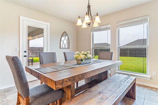 dining area featuring a chandelier and light tile patterned flooring