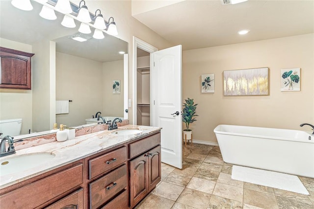 bathroom with vanity, toilet, and a bathing tub