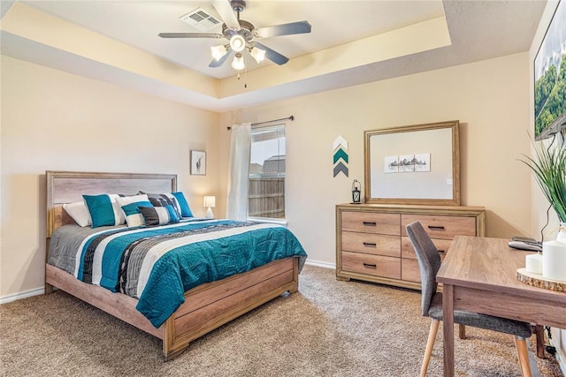 bedroom featuring carpet floors, ceiling fan, and a tray ceiling