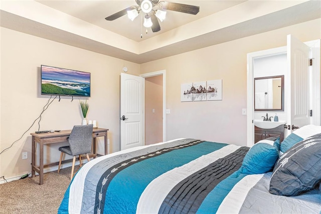 bedroom featuring ceiling fan, carpet flooring, a raised ceiling, and sink