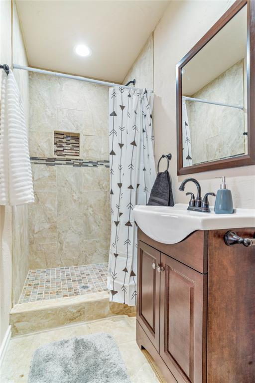 bathroom with walk in shower, tile patterned floors, and vanity