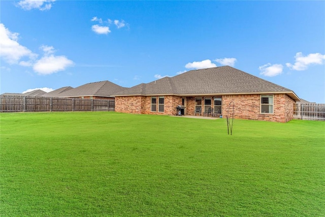 rear view of house featuring a lawn