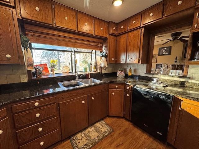 kitchen featuring black dishwasher, sink, decorative backsplash, and light hardwood / wood-style flooring