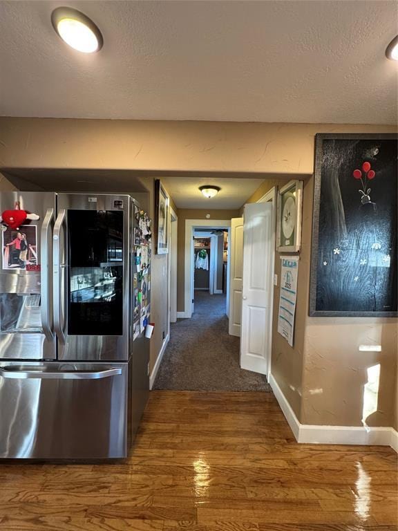 hallway with hardwood / wood-style flooring and a textured ceiling