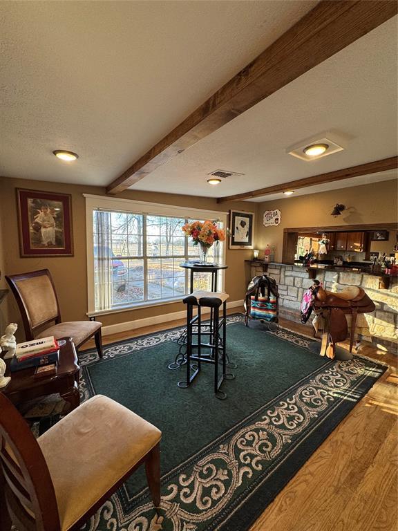 interior space with hardwood / wood-style floors, a textured ceiling, and beam ceiling