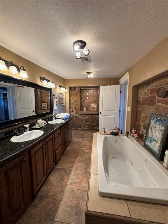 bathroom featuring vanity, a textured ceiling, and a bathing tub