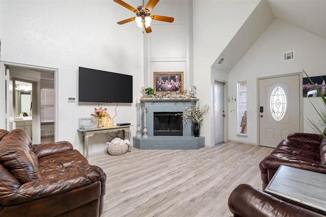 living room with high vaulted ceiling, a fireplace, light hardwood / wood-style floors, and ceiling fan