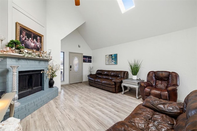 living room featuring high vaulted ceiling, a fireplace, and light hardwood / wood-style flooring