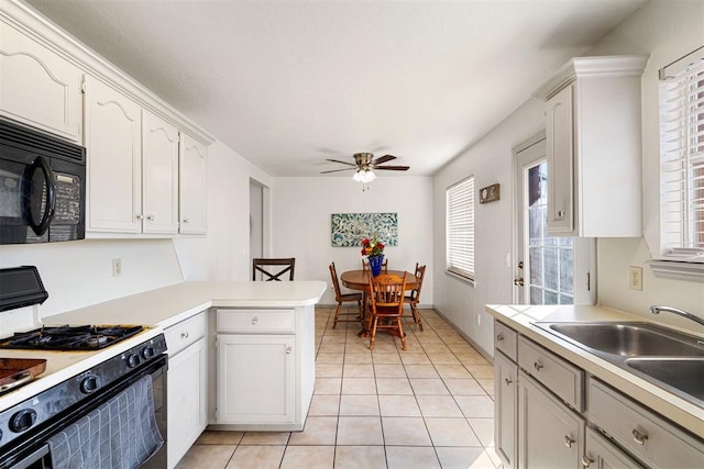 kitchen featuring sink, kitchen peninsula, gas range oven, and white cabinets