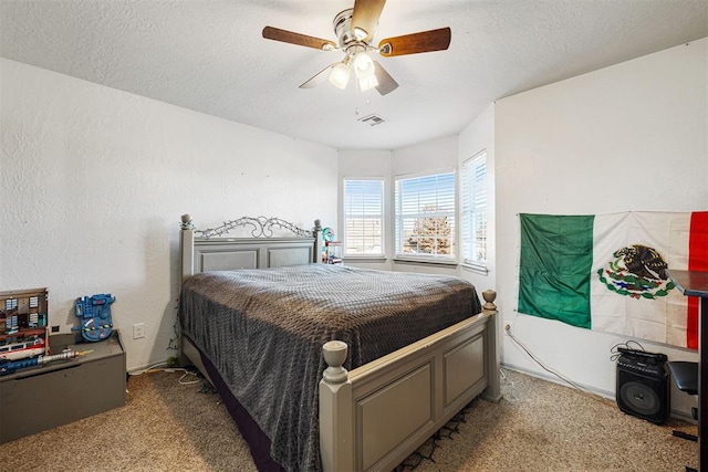 carpeted bedroom featuring ceiling fan and a textured ceiling