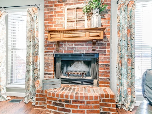 details with a fireplace, visible vents, and wood finished floors
