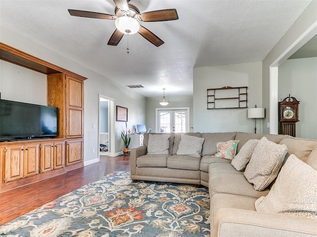 living room featuring ceiling fan, baseboards, dark wood finished floors, and visible vents