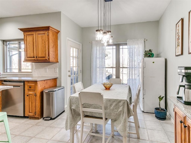 dining room with light tile patterned flooring, an inviting chandelier, and a healthy amount of sunlight
