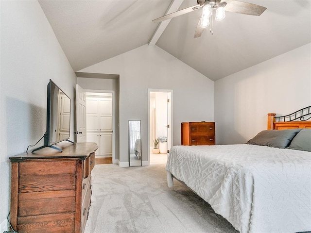bedroom featuring connected bathroom, light colored carpet, a ceiling fan, vaulted ceiling with beams, and baseboards