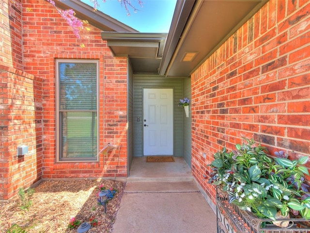 doorway to property with brick siding