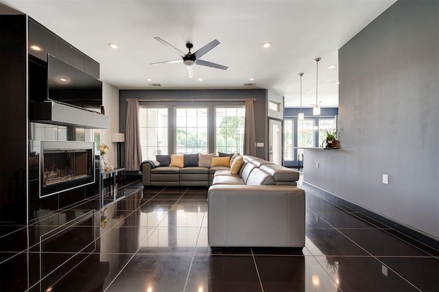 living room featuring ceiling fan and a fireplace