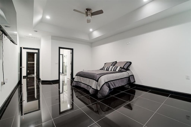 tiled bedroom with a raised ceiling and ceiling fan