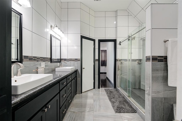 bathroom featuring vanity, tile walls, and a shower with shower door