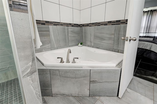 bathroom featuring tile walls and tiled bath