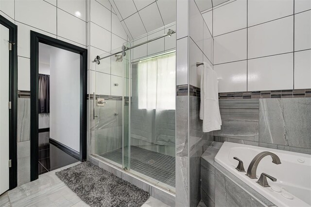 bathroom featuring tile walls, tile patterned floors, lofted ceiling, and separate shower and tub