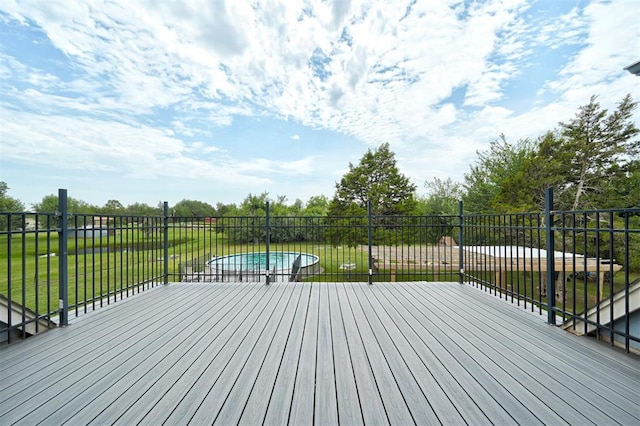 wooden terrace featuring a yard and a swimming pool