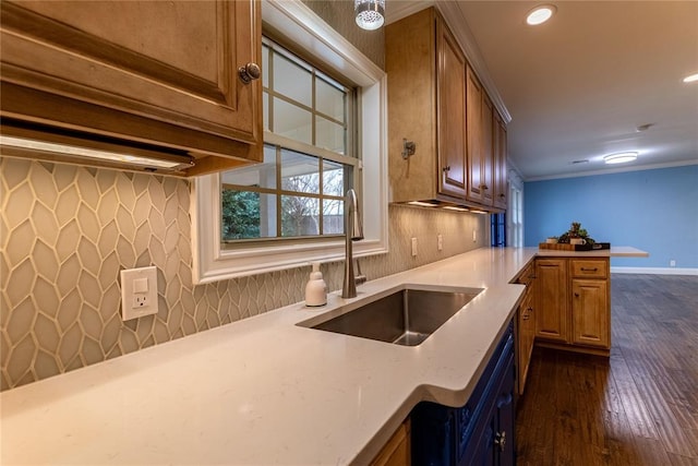 kitchen featuring dark wood-type flooring, sink, crown molding, kitchen peninsula, and decorative backsplash