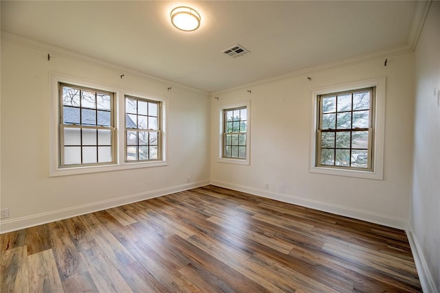 empty room featuring crown molding and dark hardwood / wood-style flooring