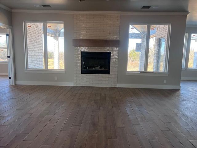 unfurnished living room with hardwood / wood-style flooring, a fireplace, and ornamental molding