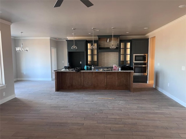 kitchen with built in microwave, stainless steel oven, wood-type flooring, a large island, and ceiling fan with notable chandelier