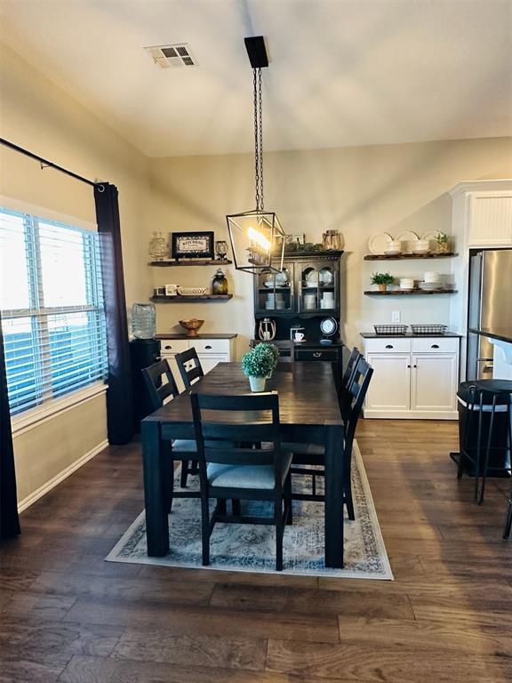 dining room featuring dark wood-type flooring, visible vents, and baseboards