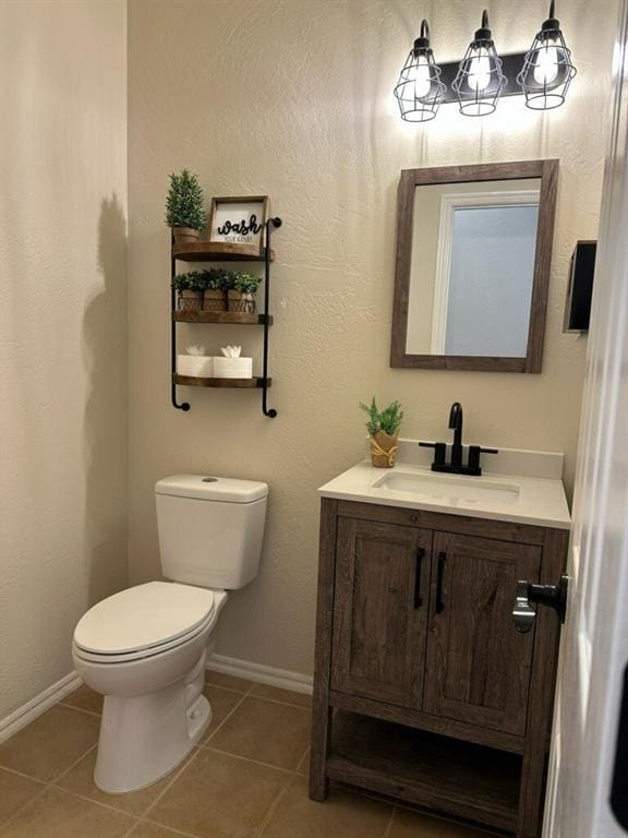 bathroom featuring baseboards, vanity, toilet, and tile patterned floors