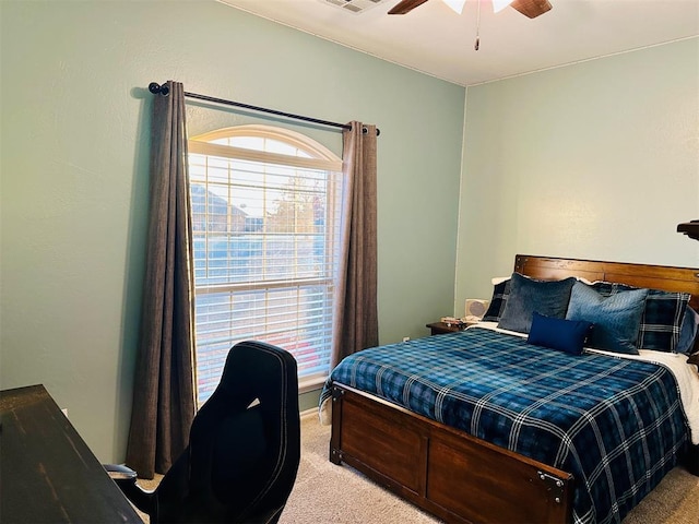 bedroom featuring visible vents, a ceiling fan, and light colored carpet