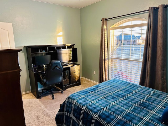 bedroom with light carpet and baseboards