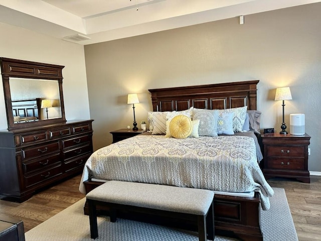 bedroom with visible vents and wood finished floors