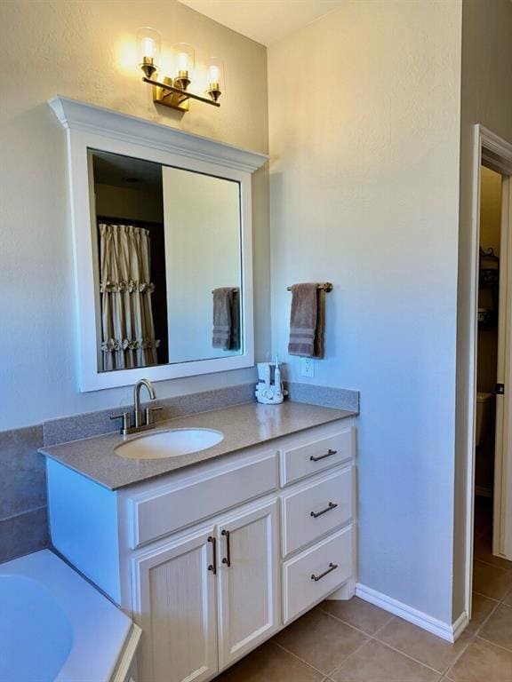 full bathroom with vanity, baseboards, a bath, and tile patterned floors