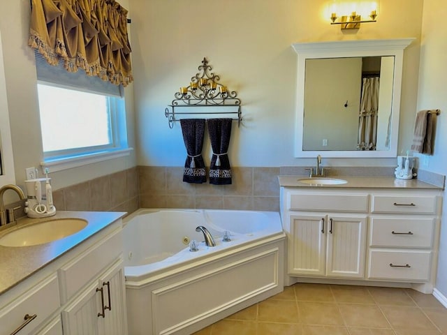 bathroom with a tub with jets, two vanities, a sink, and tile patterned floors