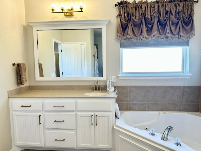 bathroom featuring plenty of natural light, a jetted tub, and vanity